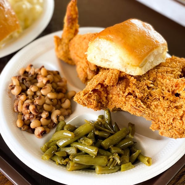 Connie's Chicken fried chicken meal with black-eyed peas, green beans, and a dinner roll.