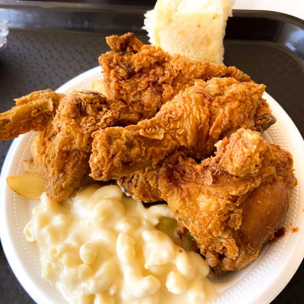 Connie's Chicken fried chicken meal with macaroni and cheese, fries, and a dinner roll.