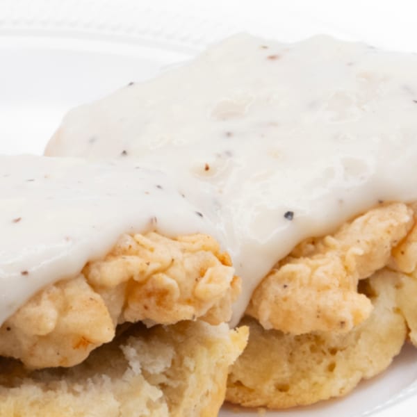 Connie's Chicken fried chicken and biscuits smothered in creamy white gravy with black pepper.